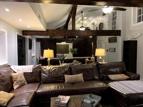 un soggiorno con divano in pelle marrone di Sweet Chic Farm Cottage with Pool, Hot-Tub and Beautiful Sunsets in Maryland a Seneca Highlands