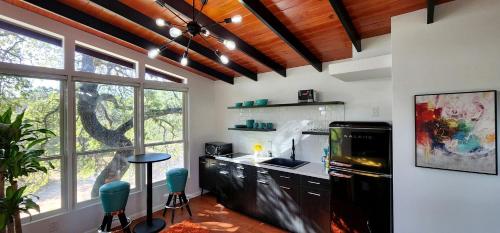 una cocina con fregadero y estufa horno superior en Romantic Escapes to Texas like No Other in this Wonderful Tree House in Leander, en Liberty Hill