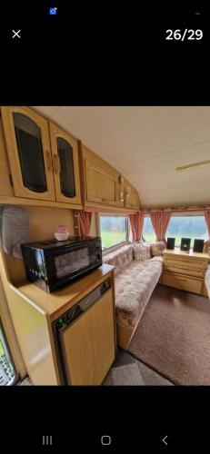 an rv with a couch and a tv in it at Parkhouse farm caravan in Easby