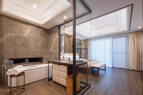 a bathroom with a sink and a table in a room at Sanya Haitang Bay Renguan Sea View Pool Villa (Water World Duty Free City Store) in Sanya
