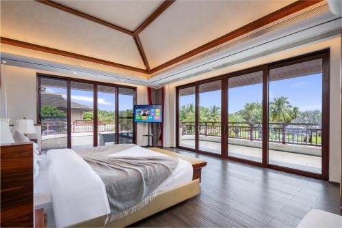 a bedroom with a bed and a large window at Sanya Haitang Bay Renguan Sea View Pool Villa (Water World Duty Free City Store) in Sanya