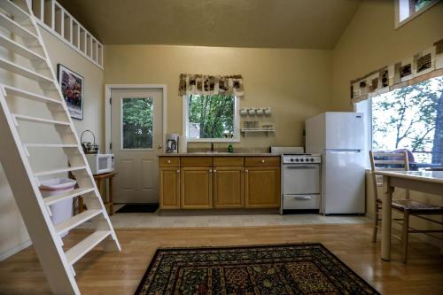 a kitchen with a white refrigerator and a ladder at Spacious Waterfront Cabin Rental on the Shores of Cook Inlet, Alaska in Kasilof