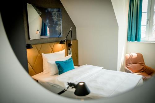 a hotel room with a bed and a chair at Motel One Hannover-Oper in Hannover