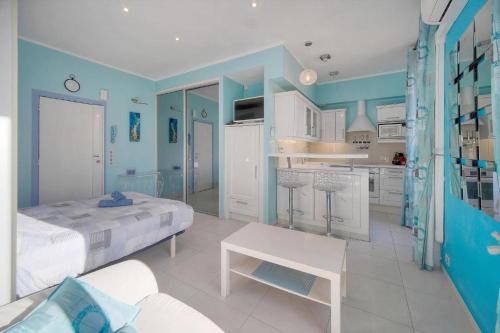 Habitación azul y blanca con cama y cocina en Studio Cannes Centre 2 min from La Croisette, en Cannes