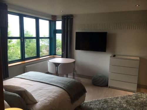 a bedroom with a bed and a tv on the wall at Penrith Retreats in Penrith