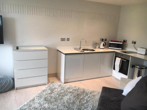 a kitchen with white cabinets and a counter top at Penrith Retreats in Penrith