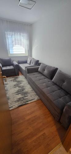 a living room with a brown couch and a rug at Stan na dan Kraljica in Bosanski Šamac