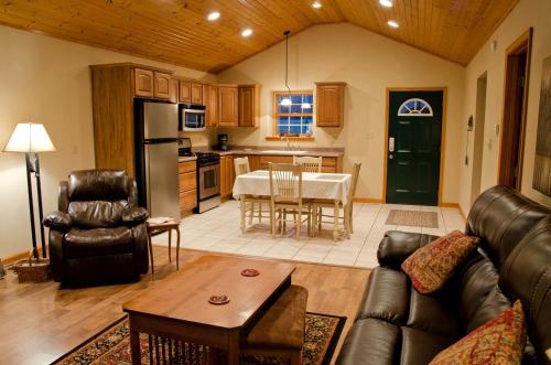 a kitchen and living room with a couch and a table at Wonderful Lakefront Cabin with Hot-tub in Carbondale, Illinois in Etherton
