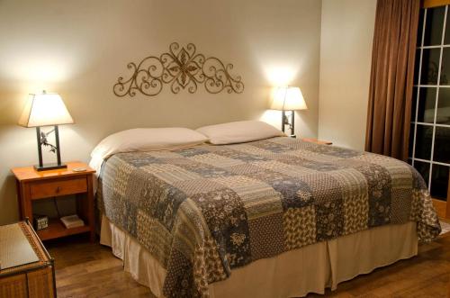 a bedroom with a bed and two lamps on tables at Wonderful Lakefront Cabin with Hot-tub in Carbondale, Illinois in Etherton