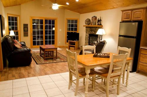 a living room with a table and a refrigerator at Wonderful Lakefront Cabin with Hot-tub in Carbondale, Illinois in Etherton
