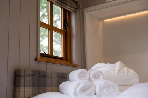 a pile of towels sitting on top of a bed at Driftwood with Hot Tub in Corpach