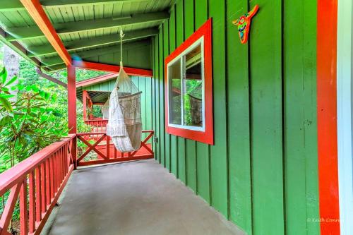 a green house with a hammock on the side of it at Charming Forest Cabin with a Hammock near Delaware Water Gap National Recreation Area, Pennsylvania in Canadensis
