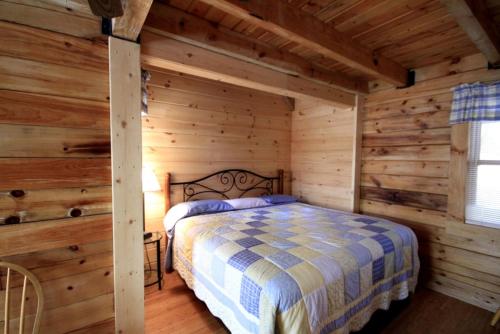 a bedroom with a bed in a log cabin at Spacious Cabin Rental with a Hot Tub near the Gauley River in West Virginia in Hico