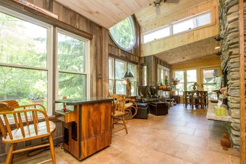 a living room with a stone fireplace and a table at Bed and Breakfast Ski Chalet with Yoga Studio in Stratton Mountain, Vermont in Stratton Mountain