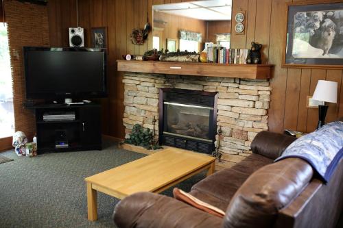 a living room with a couch and a fireplace at Rustic Family Cabin Rental with a Fire Pit near Wisconsin Dells in Tomah
