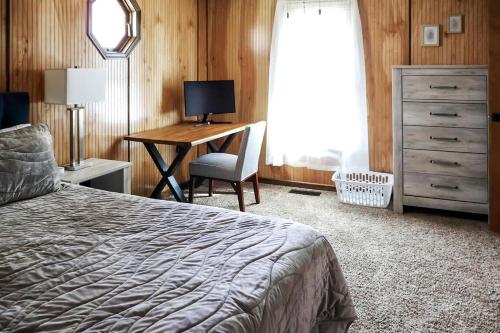 a bedroom with a bed and a desk with a computer at Cozy Mountain Cabin with Hot Tub & Scenic Views in Stanley, Virginia in Marksville