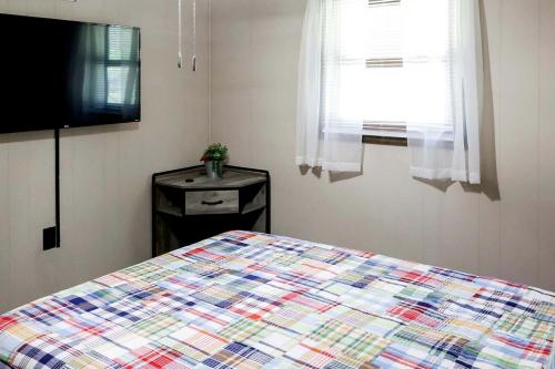 a bedroom with a bed and a flat screen tv at Cozy Mountain Cabin with Hot Tub & Scenic Views in Stanley, Virginia in Marksville