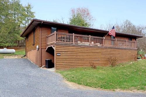 a building with a deck and an american flag on it at Cozy Mountain Cabin with Hot Tub & Scenic Views in Stanley, Virginia in Marksville