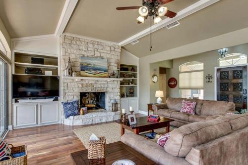 un soggiorno con divano e camino di Spacious Cottage Rental on the Shores of Cedar Creek Lake in Mabank, Texas a Enchanted Oaks
