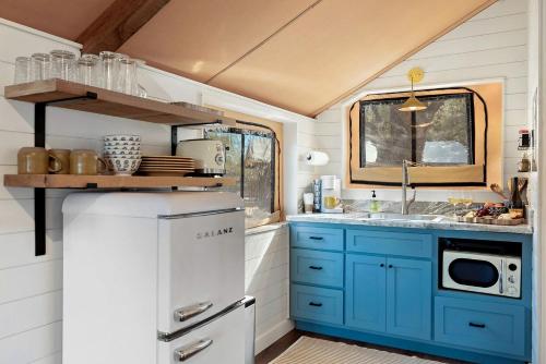 a kitchen with blue cabinets and a sink at Beautiful Tented Cabin in Texas for Glamping by Guadalupe River in Hunt