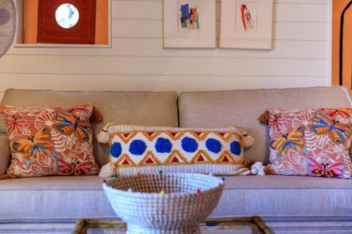 a couch with pillows and a bowl on a table at Beautiful Tented Cabin in Texas for Glamping by Guadalupe River in Hunt