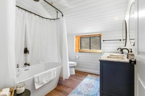 a white bathroom with a tub and a toilet at Beautiful Tented Cabin in Texas for Glamping by Guadalupe River in Hunt