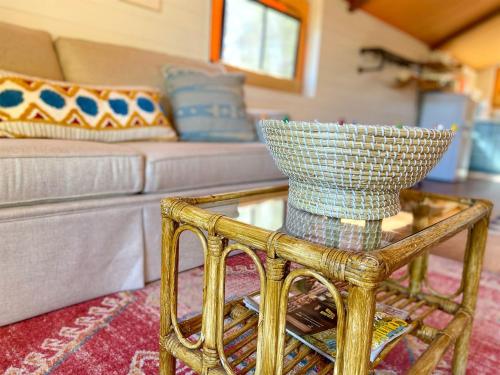 a glass table with a basket on top of it in a living room at Beautiful Tented Cabin in Texas for Glamping by Guadalupe River in Hunt