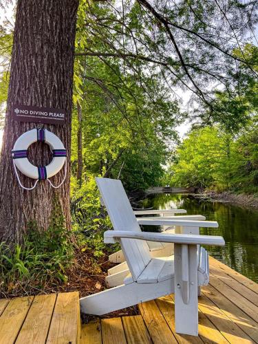 a white bench sitting on a dock next to a tree at Secluded Romantic Yurt with Amazing Views in Dripping Springs, Texas in Hammetts Crossing