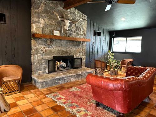 a living room with a stone fireplace and a red leather couch at Secluded Romantic Yurt with Amazing Views in Dripping Springs, Texas in Hammetts Crossing
