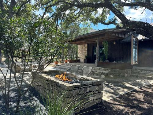 a stone fire pit in front of a house at Secluded Romantic Yurt with Amazing Views in Dripping Springs, Texas in Hammetts Crossing