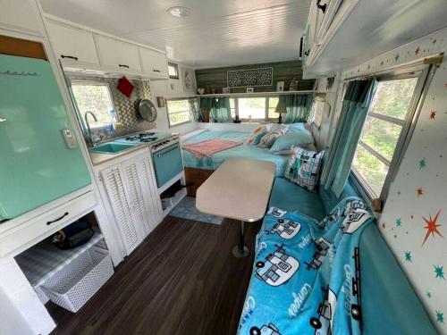ein Innenraum eines Wohnmobils mit einem Schlafzimmer und einer Küche in der Unterkunft Marble Falls Retro Caravan Glamping: Your Vintage Getaway Awaits in Marble Falls