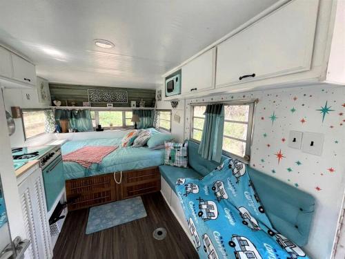 ein Schlafzimmer in einem Wohnmobil mit zwei Betten und einer Küche in der Unterkunft Marble Falls Retro Caravan Glamping: Your Vintage Getaway Awaits in Marble Falls