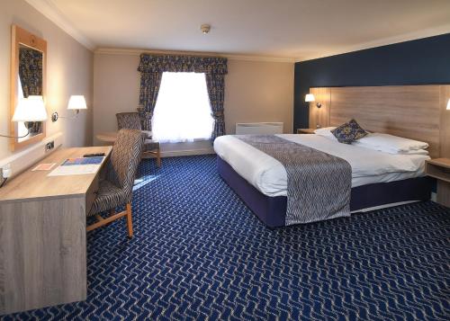 a hotel room with a bed and a desk at The Queens Hotel & Victoria Cloisters Apartments in York