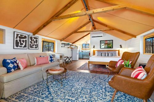 a living room with a couch and a bed at Glamping Vacations in a Luxury Tented Cabin near River Guadalupe, in Ingram, Texas in Hunt
