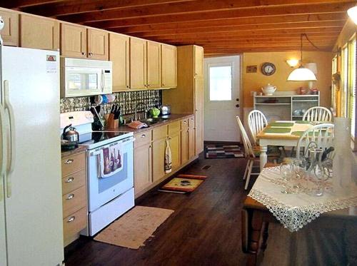 a kitchen with a white refrigerator and a table at Waterfront Cabin Perfect for Families in Inverness, Florida in Inverness