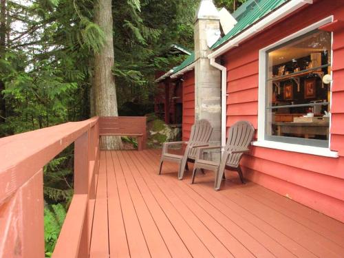 a deck with two chairs and a table on a house at Pet-Friendly Cabin Rental Overlooking a River near Skykomish, Washington in Baring