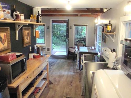 a kitchen with a sink and a table with a microwave at Pet-Friendly Cabin Rental Overlooking a River near Skykomish, Washington in Baring