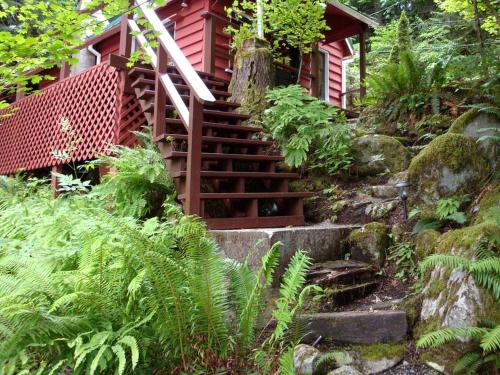 a set of stairs leading to a red house at Pet-Friendly Cabin Rental Overlooking a River near Skykomish, Washington in Baring