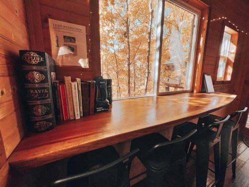 a library with a wooden table and a window at Stunning Tree House Tucked Away Among the Trees near Germantown, Kentucky in Germantown