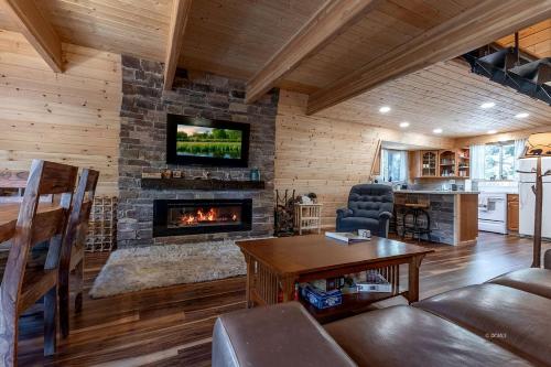 Una sala de estar con chimenea en una cabaña de troncos en Peaceful Cabin Surrounded by Nature for a Memorable Getaway in Duck Creek Village, Utah, en Duck Creek Village