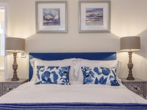 Un dormitorio con una cama azul y blanca con dos lámparas. en 2 Bed in Westward Ho 77589, en Northam
