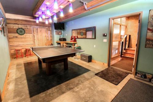 a ping pong table in the middle of a room at Colorful Cabin with Hot-Tub, Game Room and Gym in Montana in Coram