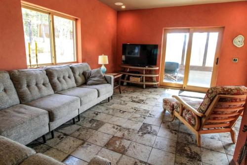 a living room with a couch and a tv at Colorful Cabin with Hot-Tub, Game Room and Gym in Montana in Coram