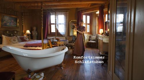 une femme prenant une photo d'une chambre avec baignoire dans l'établissement Exempel Schlafstuben und Quartier Langer Hals, à Tangermünde