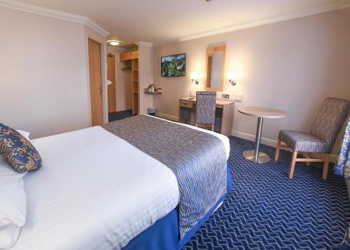 a hotel room with a bed and a desk at The Queens Hotel & Victoria Cloisters Apartments in York