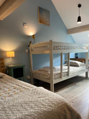 a bedroom with two bunk beds and a lamp at Gîte de la Pisserotte in Montigny-sur-Armançon