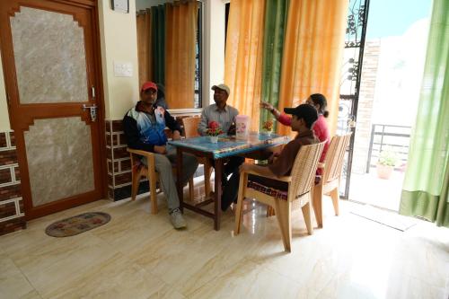a group of people sitting around a table at maa kalishila home stay in Ukhimath