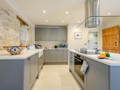 a large kitchen with white counter tops and cabinets at 2 Bed in Tisbury 78165 in Tisbury