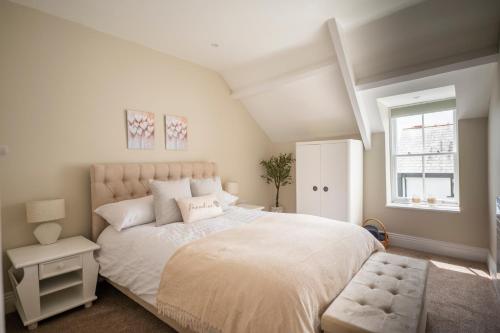 Un dormitorio con una cama blanca grande y una ventana en Luxury Tenby Old Town Retreat just 1-minute to Beach with Parking, en Pembrokeshire