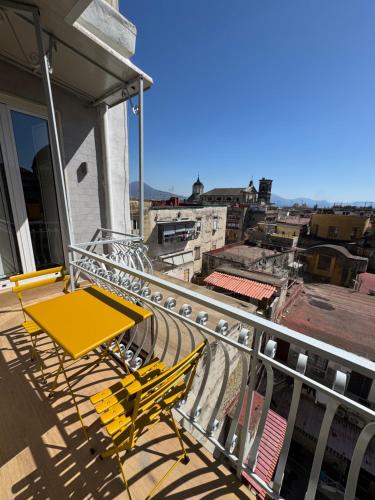a yellow chair on a balcony with a view at WANDERLUST SPACCANAPOLI Points Of View in Naples